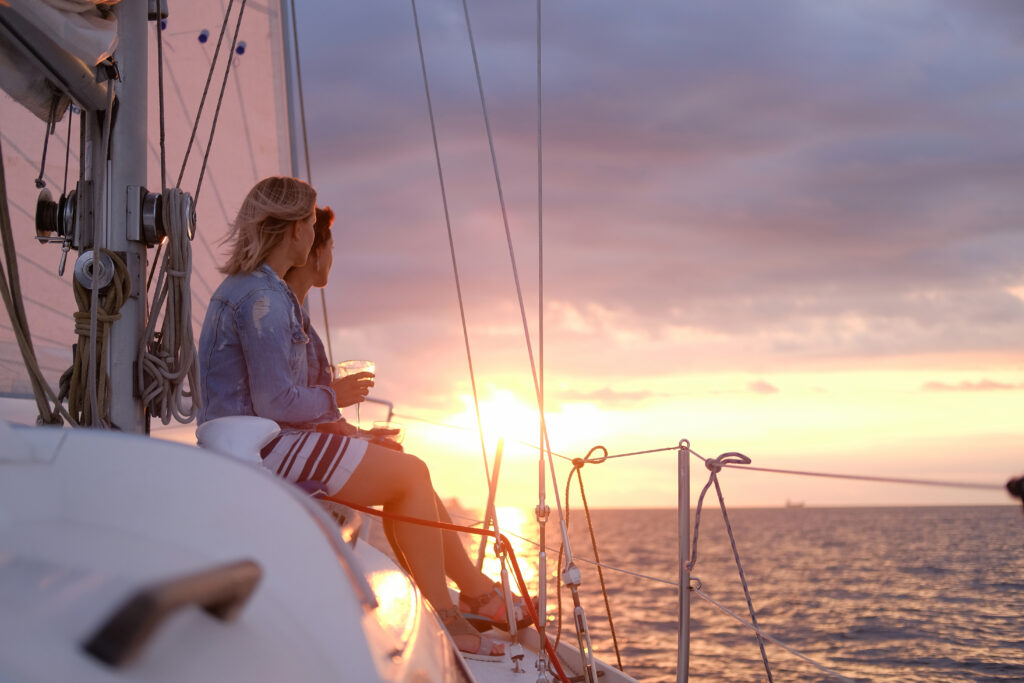 couple of cheerful girls are enjoying their trip on yacht